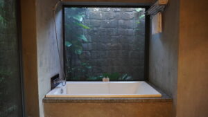 富國島森林系飯店 Lahana Resort 浴室實拍：半戶外設計、木質調 freestanding 浴缸與繁茂綠意